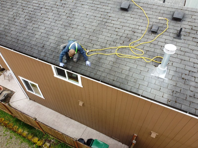 worker cleaning house gutter from leaves and dirt