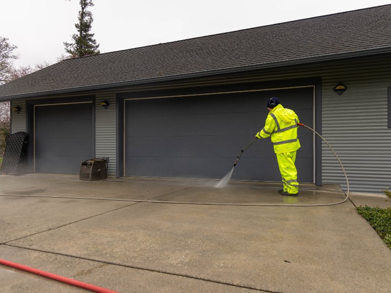 pressure washing a concrete surface to clean it