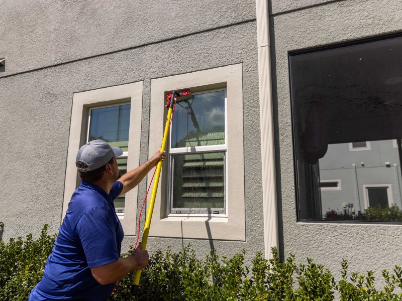 a professional window cleaner using a squeegee to clean a window