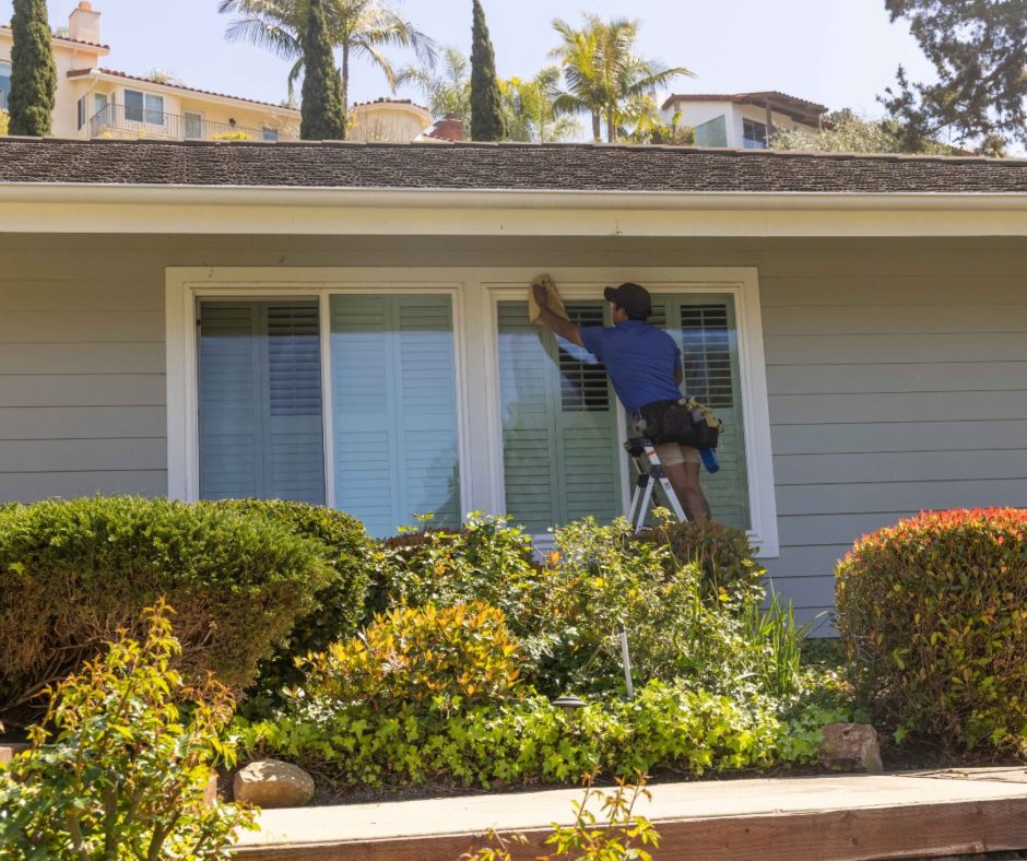 a person using a squeegee to clean a large window